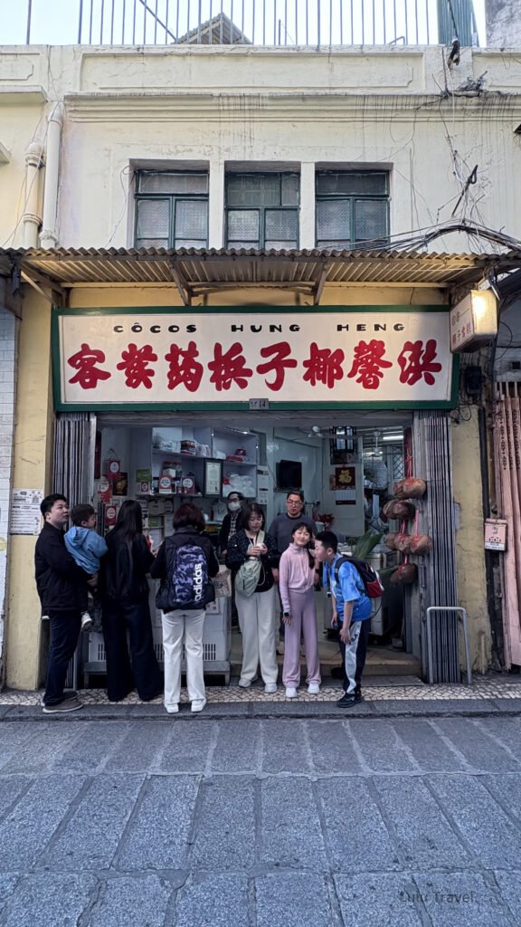 澳門老字號椰子冰店門口排隊人潮，傳統招牌與在地生活氣息