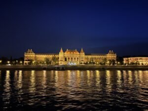 布達佩斯多瑙河畔的歷史建築群夜景，燈光勾勒出對稱的建築輪廓，展現歐洲古典都會的靜謐美學。