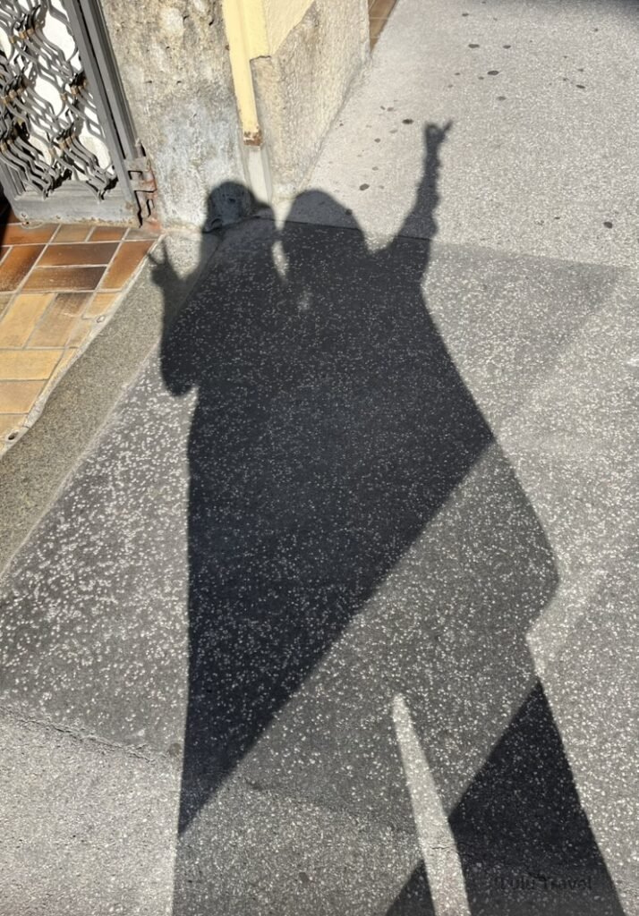 與長輩在奧地利薩爾斯堡街頭的影子合影，午後陽光下留下旅行的溫柔紀念