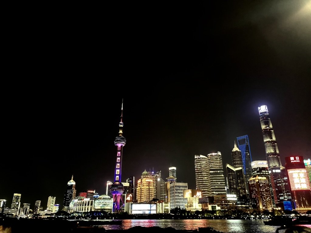 上海外灘夜景與陸家嘴天際線，東方明珠塔、上海中心大廈等地標在夜晚燈光下的城市景觀