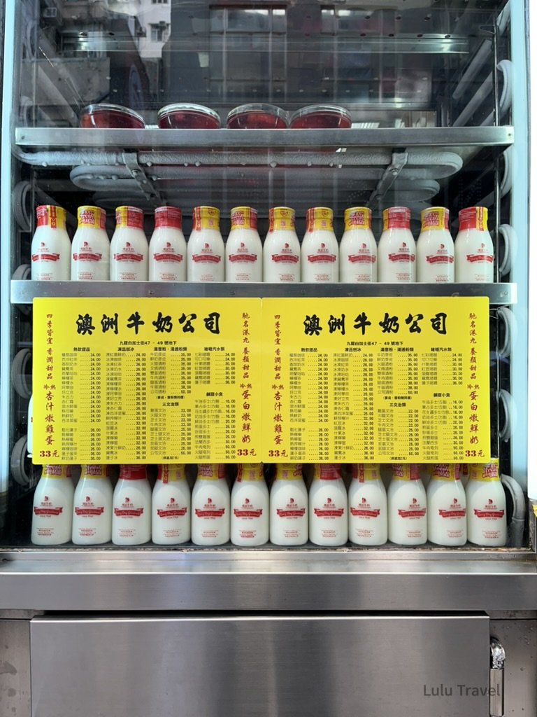 香港中環老字號茶餐廳冰櫃，整齊排列的澳洲牛奶公司瓶裝牛奶與菜單，呈現經典港式早餐與懷舊飲食文化