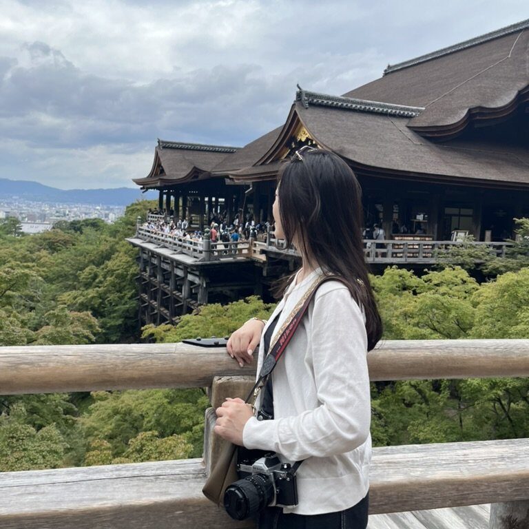 匈牙利布達佩斯漁夫堡觀景台，一名旅人倚靠石柱眺望多瑙河與對岸國會大廈，背景是布達佩斯城市天際線