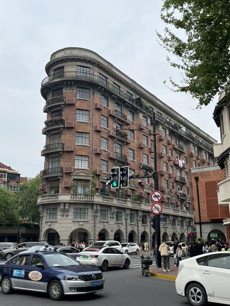 上海武康大樓（Wukang Mansion），位於淮海中路與武康路口的紅磚弧形租界建築，是上海知名城市地標之一