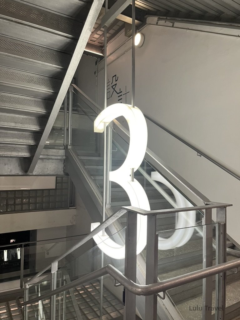 香港 PMQ 元創方室內樓梯空間，大型發光數字裝置結合工業風建築設計，展現香港設計場域特色
