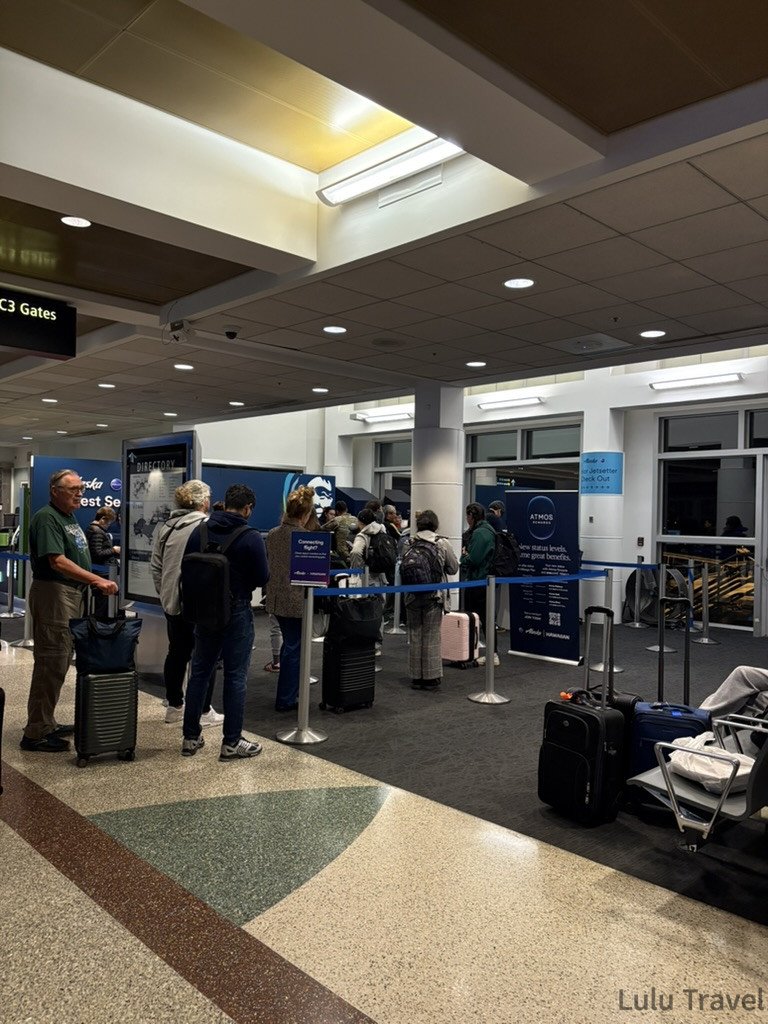 西雅圖機場阿拉斯加航空（Alaska Airlines）客服櫃檯深夜排隊實錄，大批旅客因班機延誤正在排隊領取餐券與住宿券，展現真實的機場維權現場。