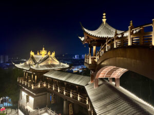 義烏雞鳴閣高處俯拍夜景，中式屋頂群與弧形迴廊錯落分布，遠方義烏市區燈火點綴夜空