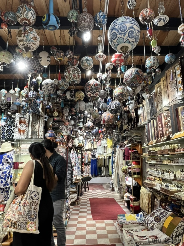 大巴札內著名陶瓷店天花奇景，數百個伊茲尼克風格藍陶盤、彩繪陶盤密集掛滿，紅、藍、綠、黃色彩交織，呈現土耳其手工藝的豐富多樣，土耳其跟團必訪的紀念品購物地點
